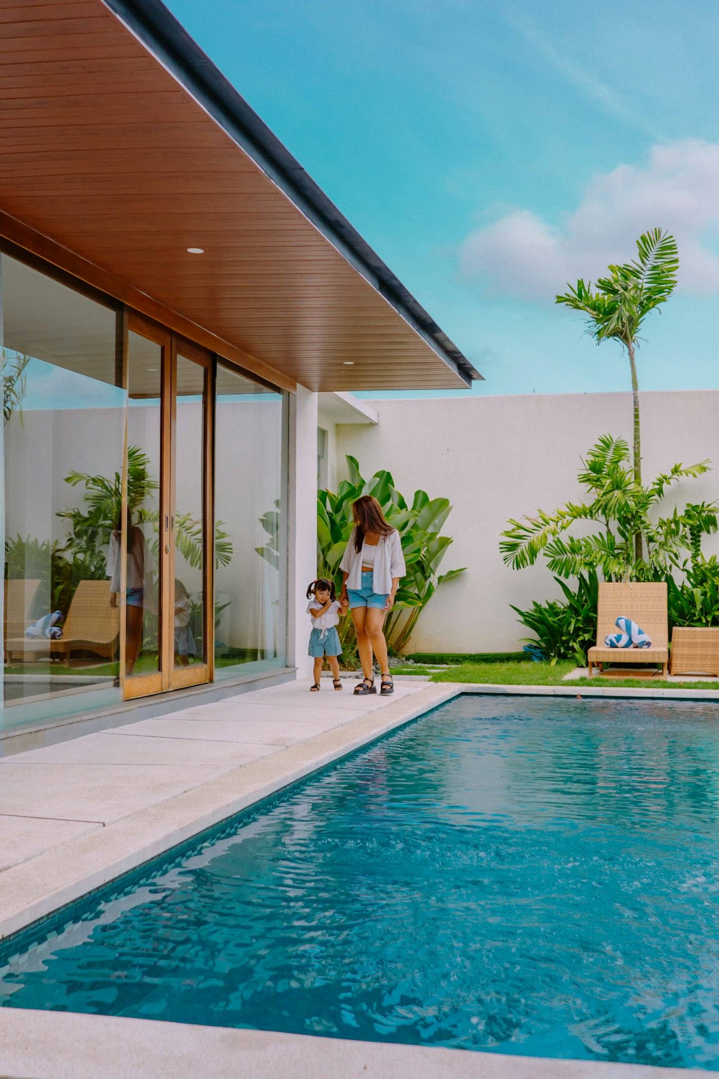 Mother and child walking beside a villa pool