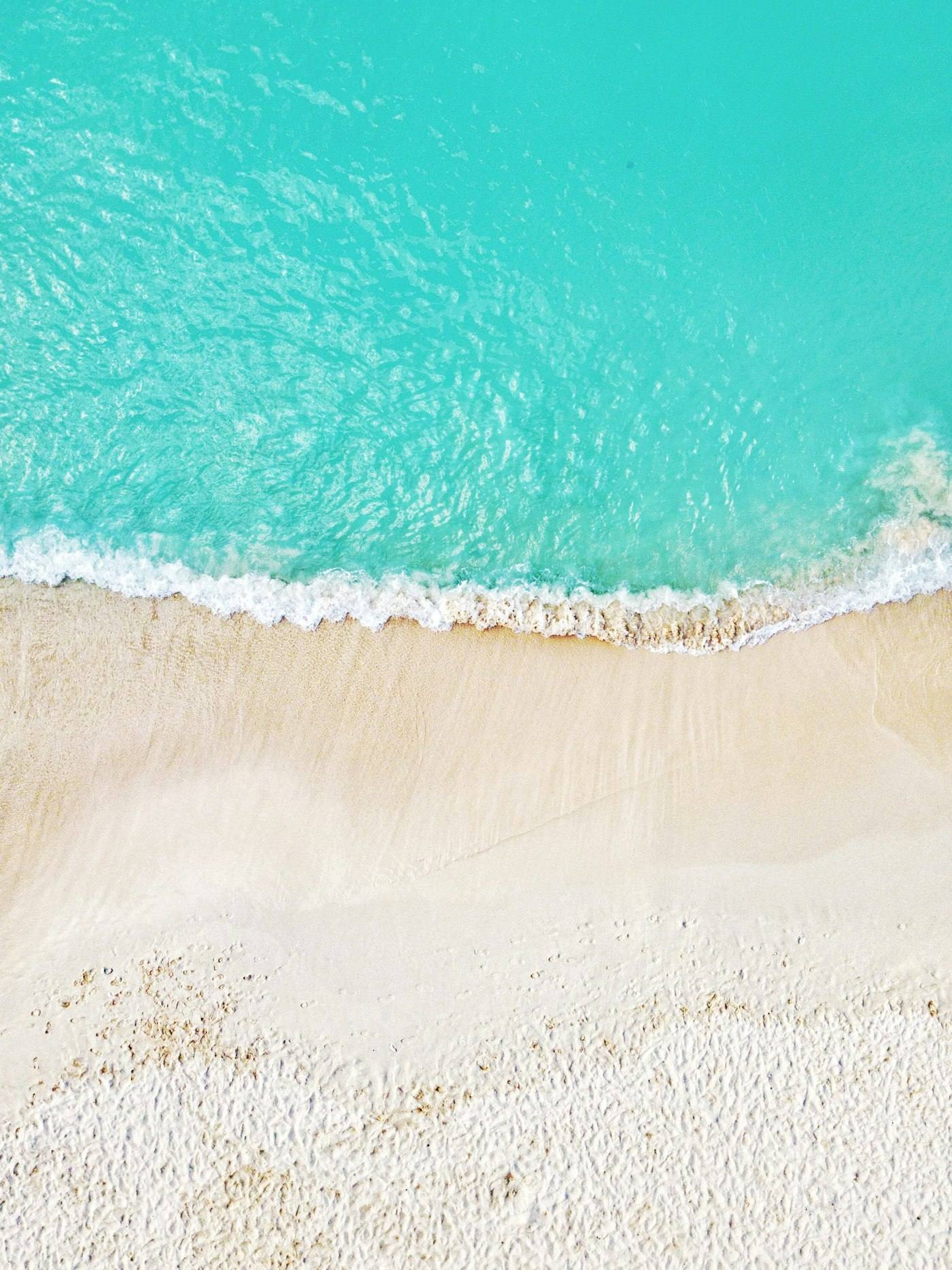 Aerial view of a white-sand beach and turquoise water in the Cayman Islands