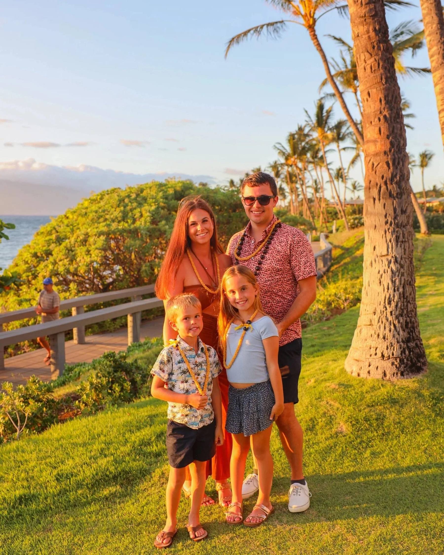 Kristina and her family in leis at sunset before the luau