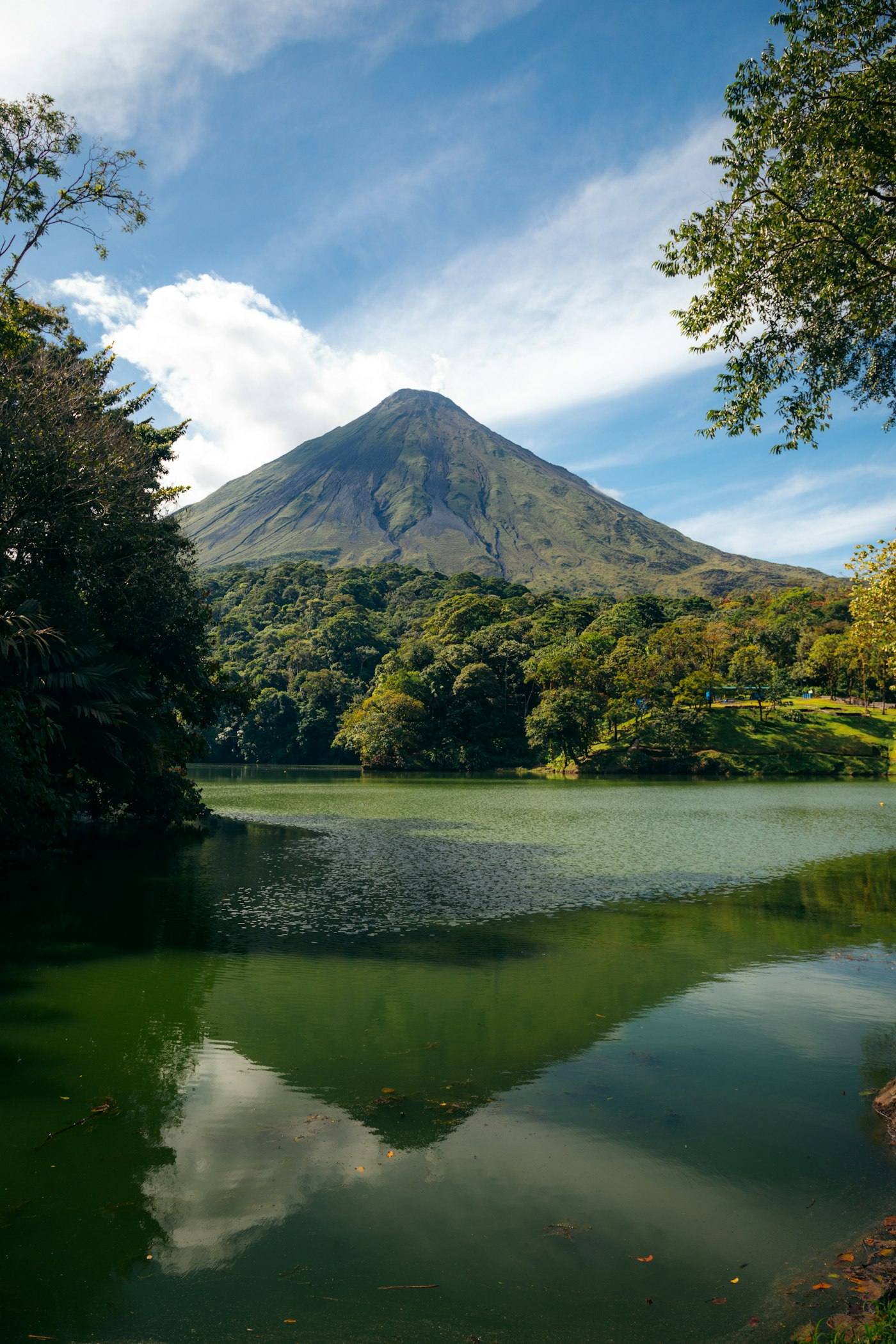 Arenal Volcano reflected in a lake surrounded by rainforest in Costa Rica