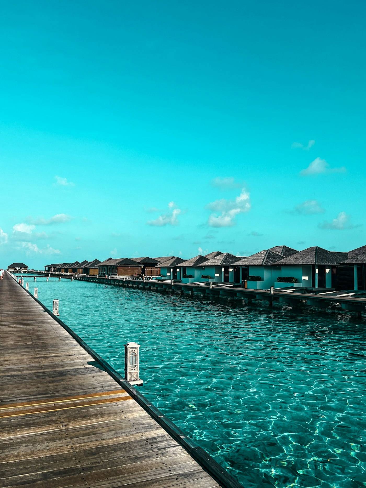 Overwater bungalows over a clear turquoise ocean