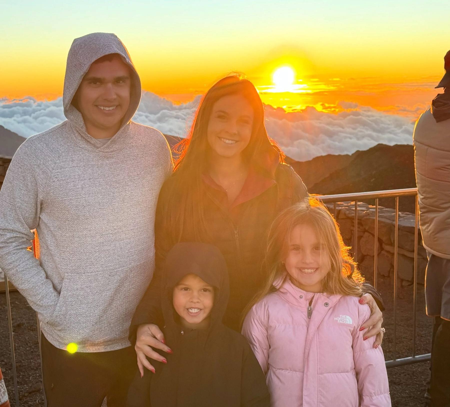 Kristina and her family at sunrise above the clouds on Haleakalā