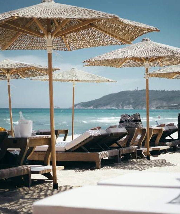 Beach club loungers and straw umbrellas facing the sea