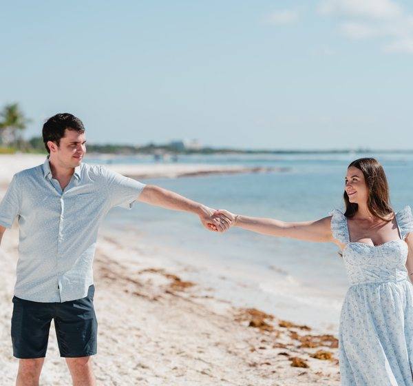 Kristina and her husband holding hands on the beach